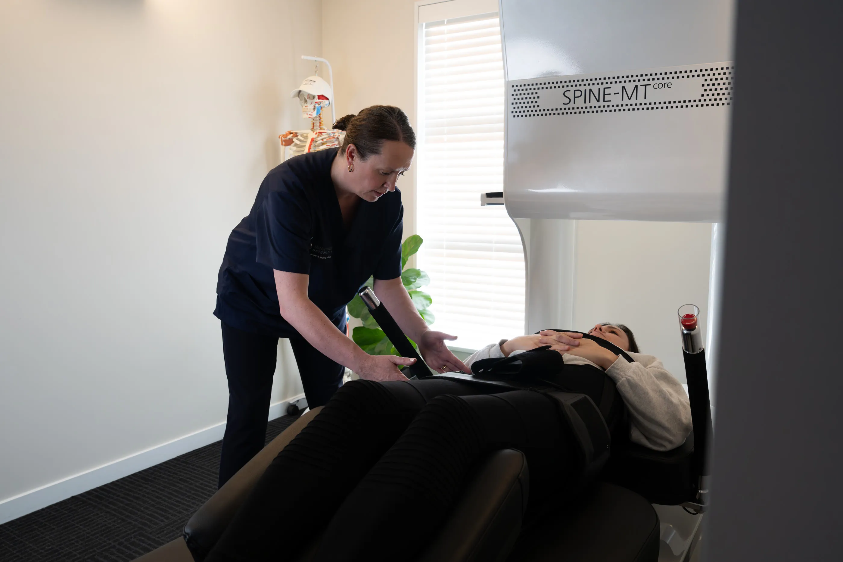 Lorraine Herity adjusting the support harness for a patient on the Spine-MT spinal decompression table
