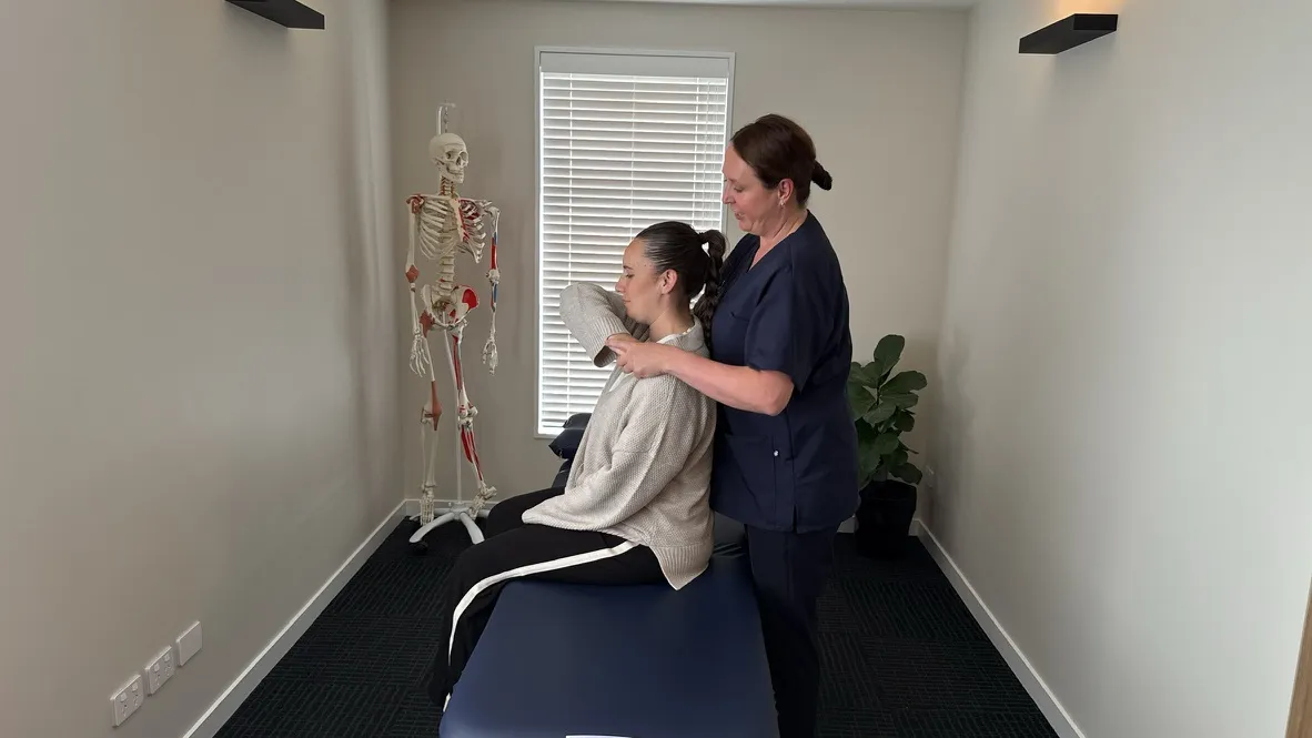 Lorraine Herity performing cervical osteopathic treatment on an adult female patient seated on a treatment bench